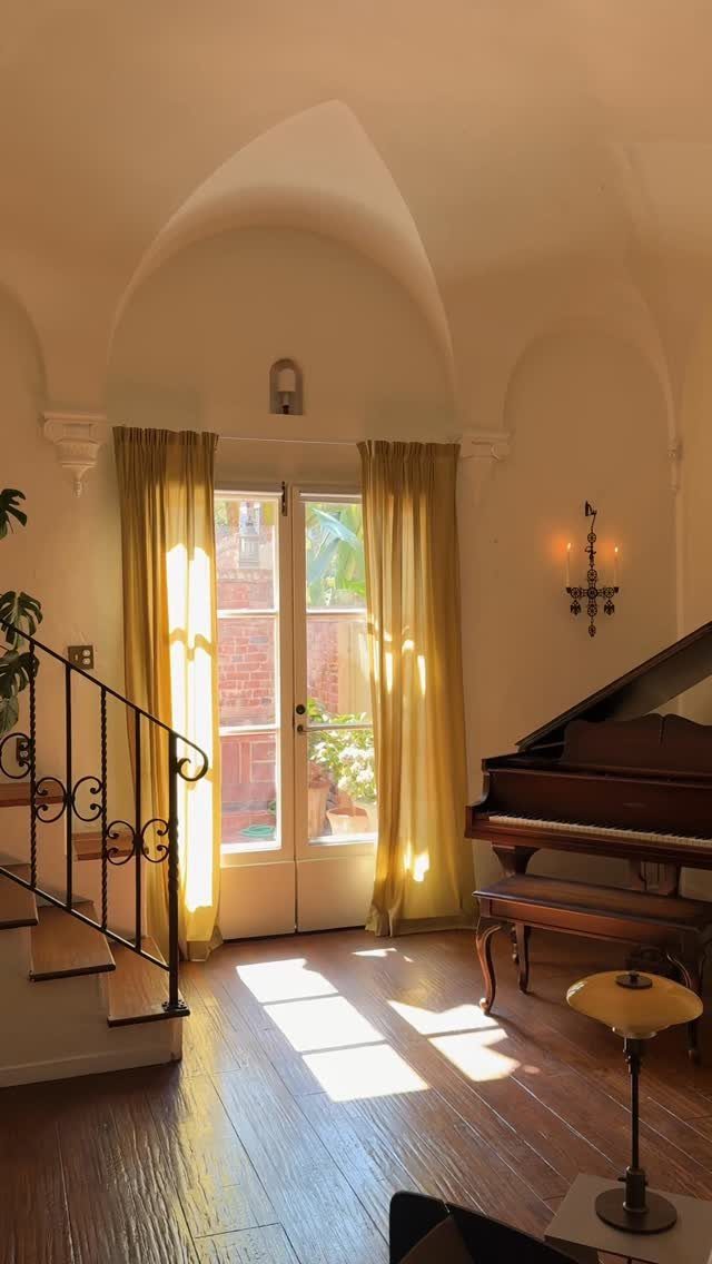 Yellow curtains hanging above glass French doors in a room with arched ceilings.