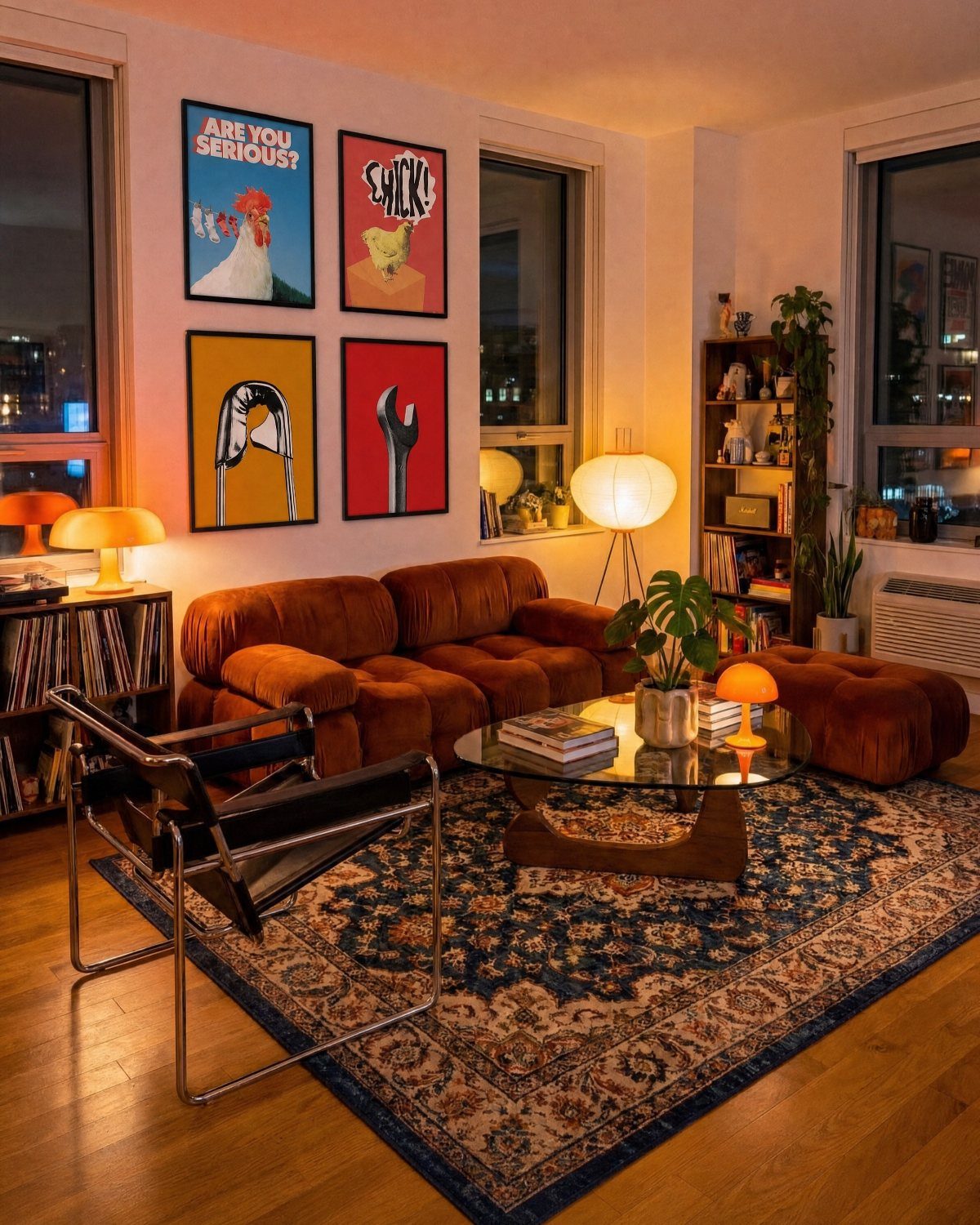 Four large colorful graphic art prints hanging on a wall above a brown sofa.