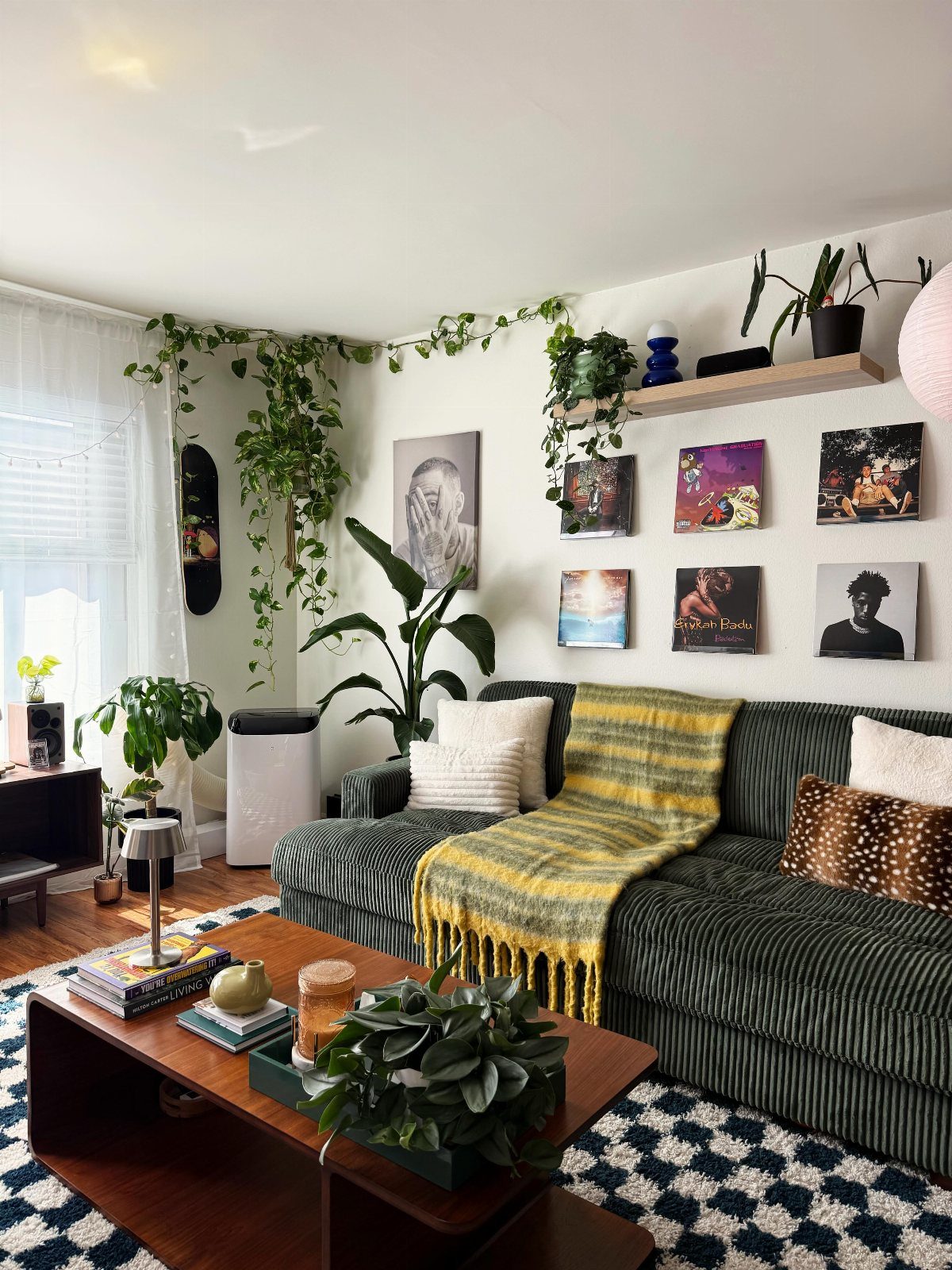 Living room with a green sofa and a gallery wall of art prints.