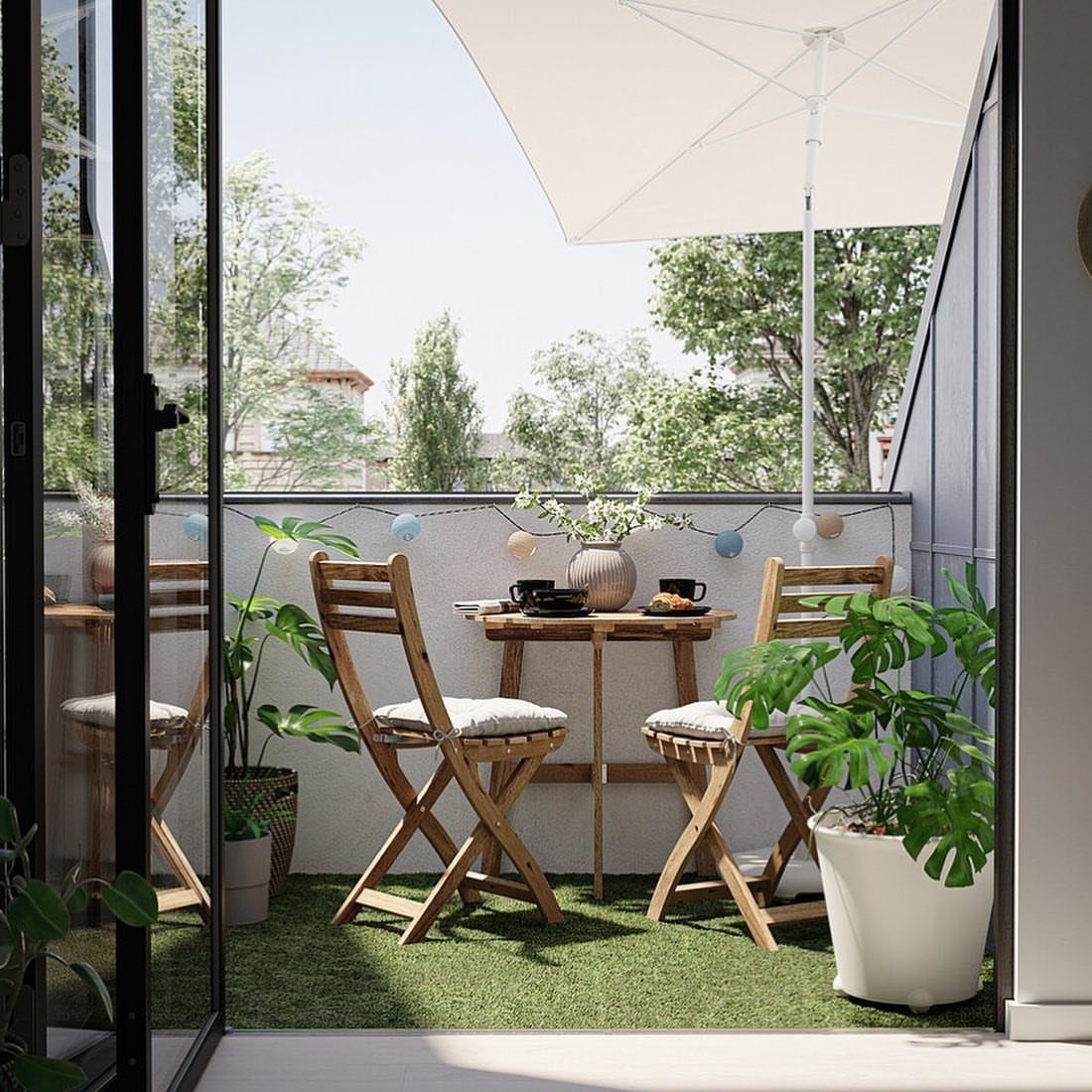 Wooden folding table and chairs on a green balcony with a white umbrella