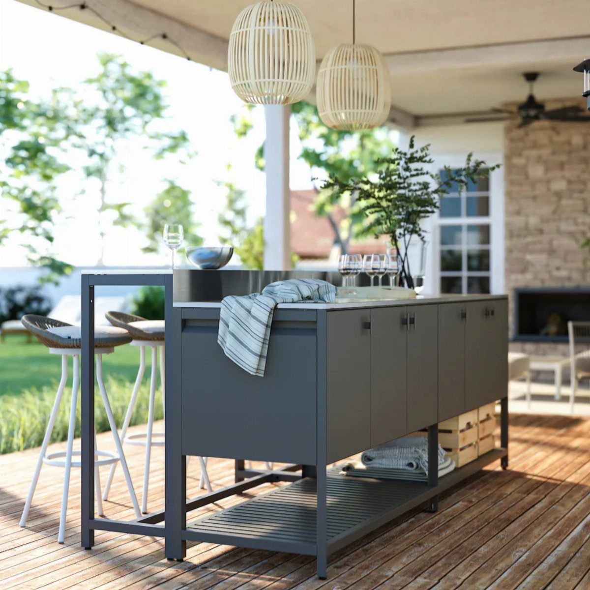 Grey outdoor kitchen island with bar stools on a wooden patio deck