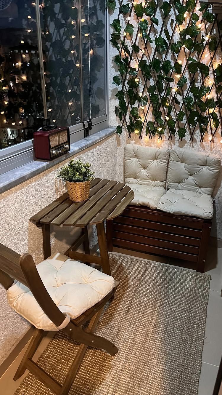 Wooden outdoor furniture set with beige cushions on a patio with fairy lights.