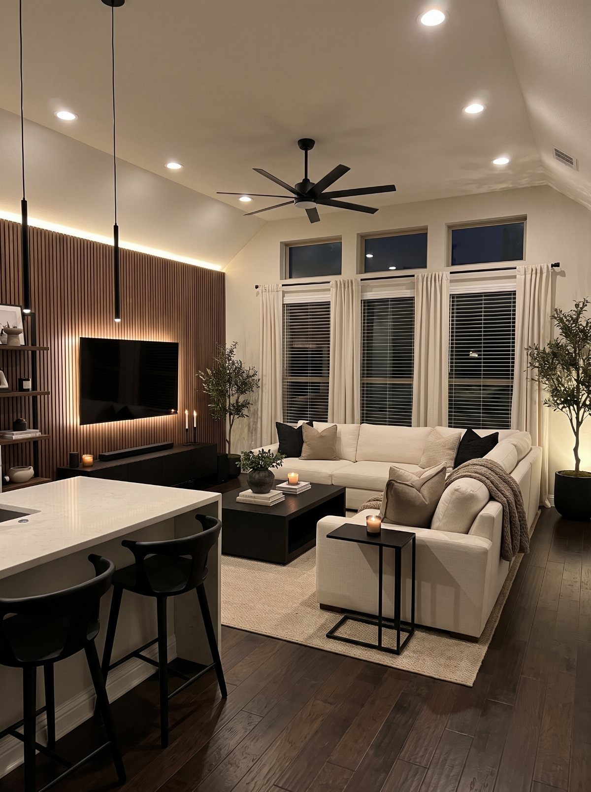 Modern living room with white sofa, black furniture, and dark wood flooring.