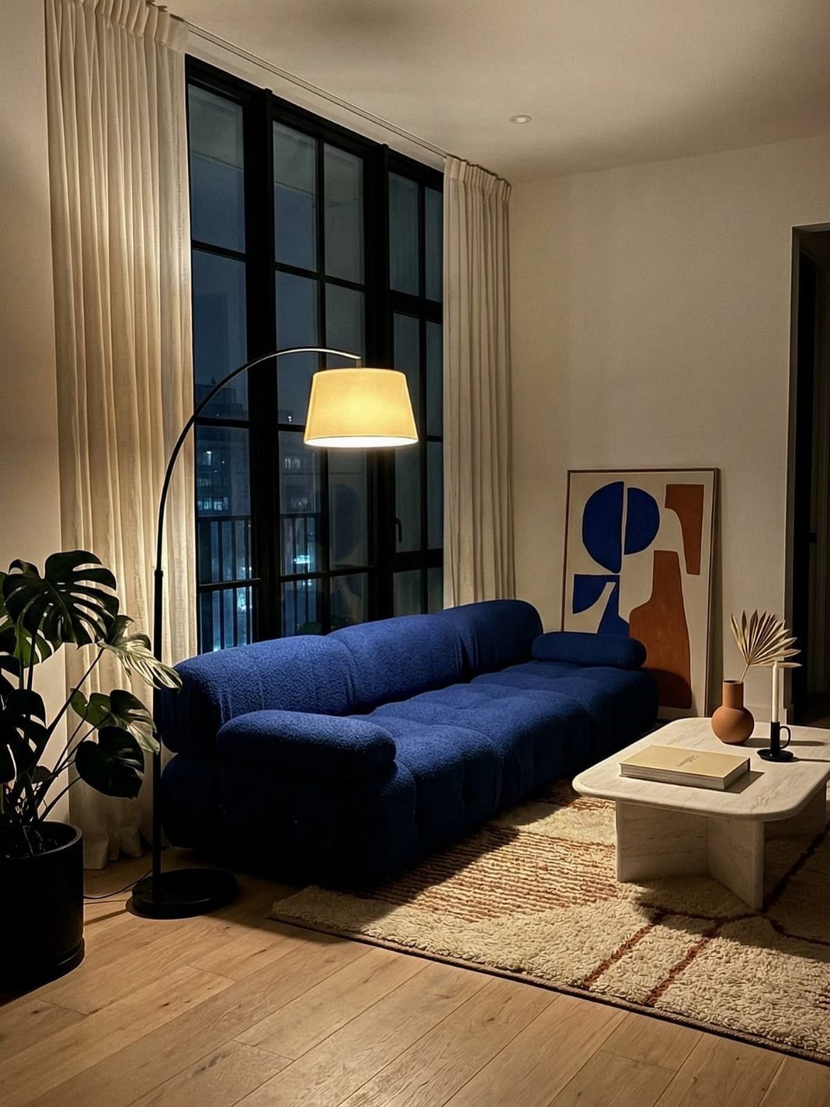 Royal blue textured sofa in a minimal living room with a white coffee table.