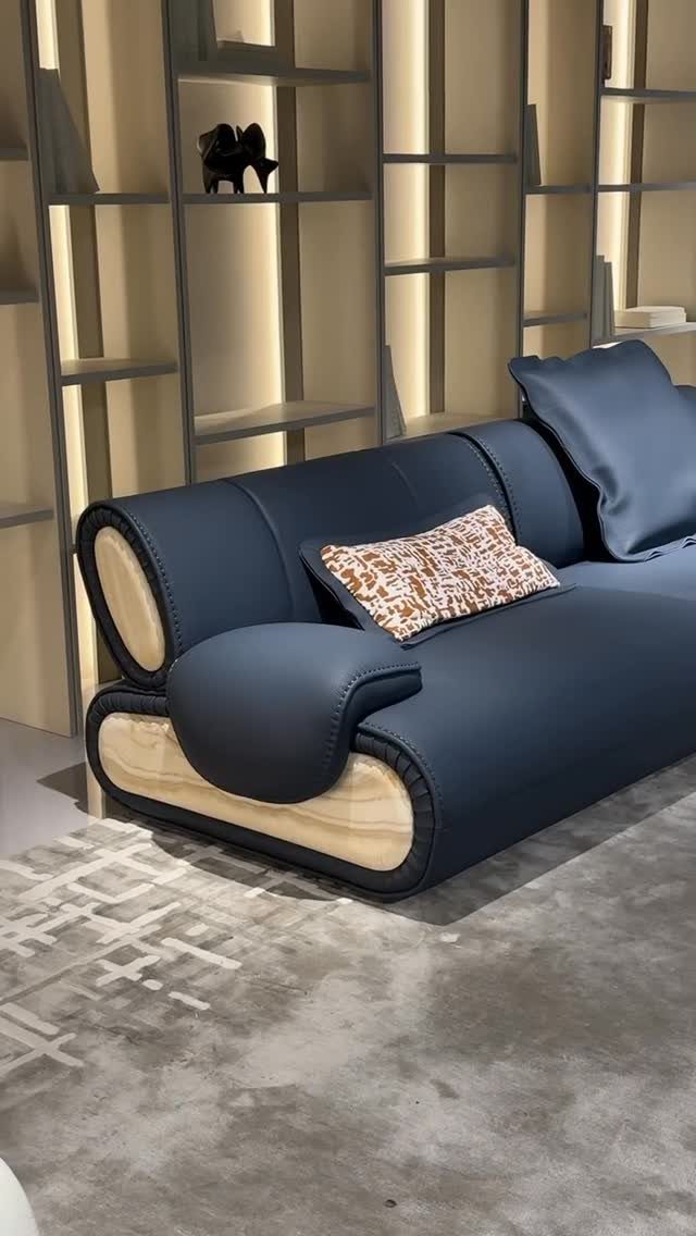 Navy blue modern sofa with a patterned pillow in a minimalist room
