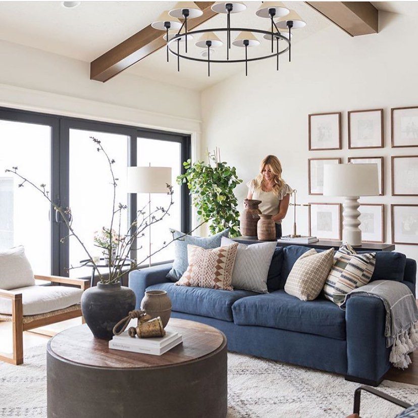 Navy blue sofa with patterned throw pillows in a bright, modern living room.