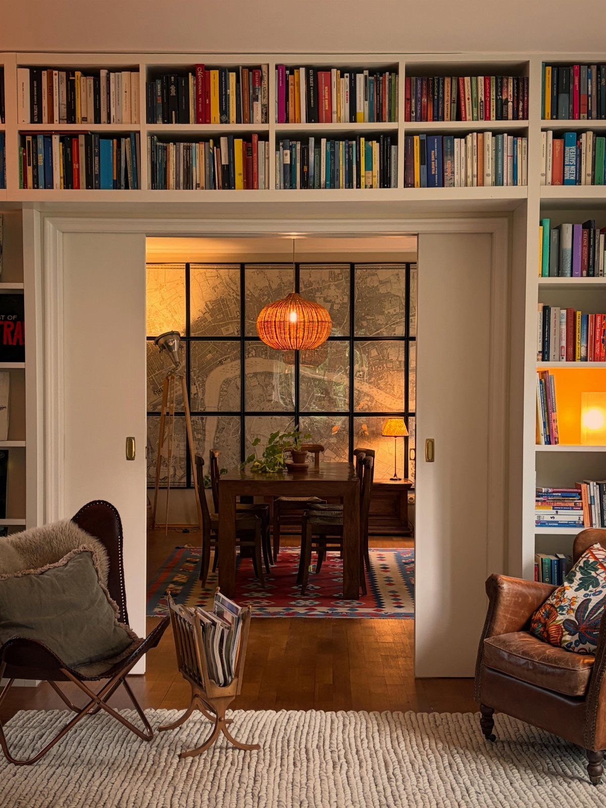 White built-in bookshelves filled with books installed above a wide interior doorway.