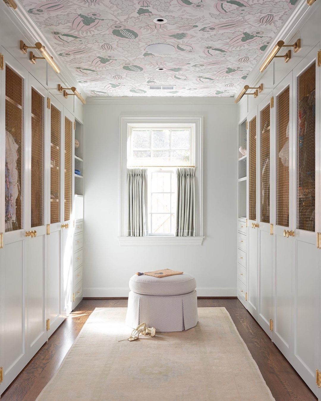 Dressing room with white wardrobes and patterned wallpaper on the ceiling
