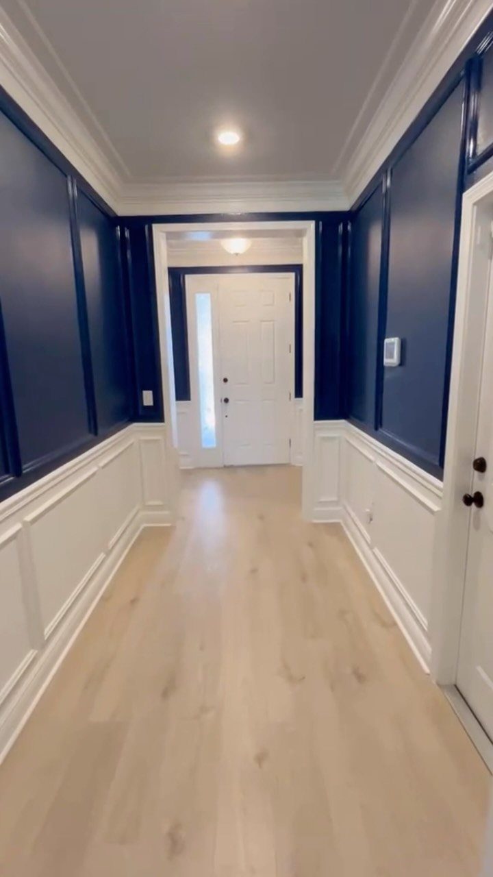 Navy blue and white two-tone hallway walls with a classic white chair rail.