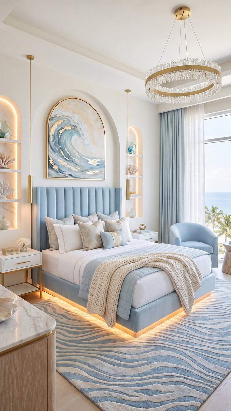 Coastal bedroom with light blue furniture, wave artwork, and a crystal chandelier.