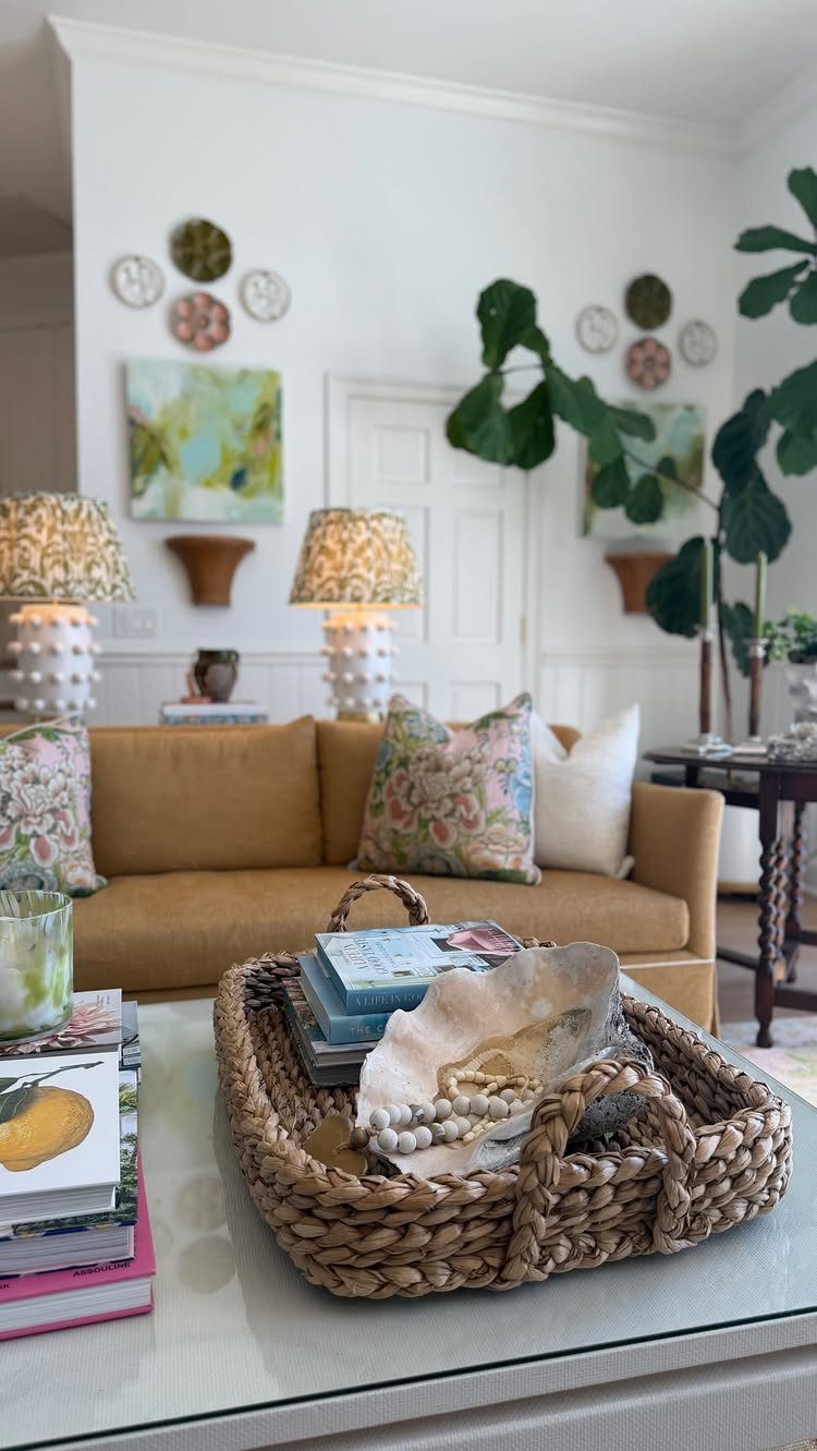 Tan sofa and woven wicker tray in a bright coastal living room setting.