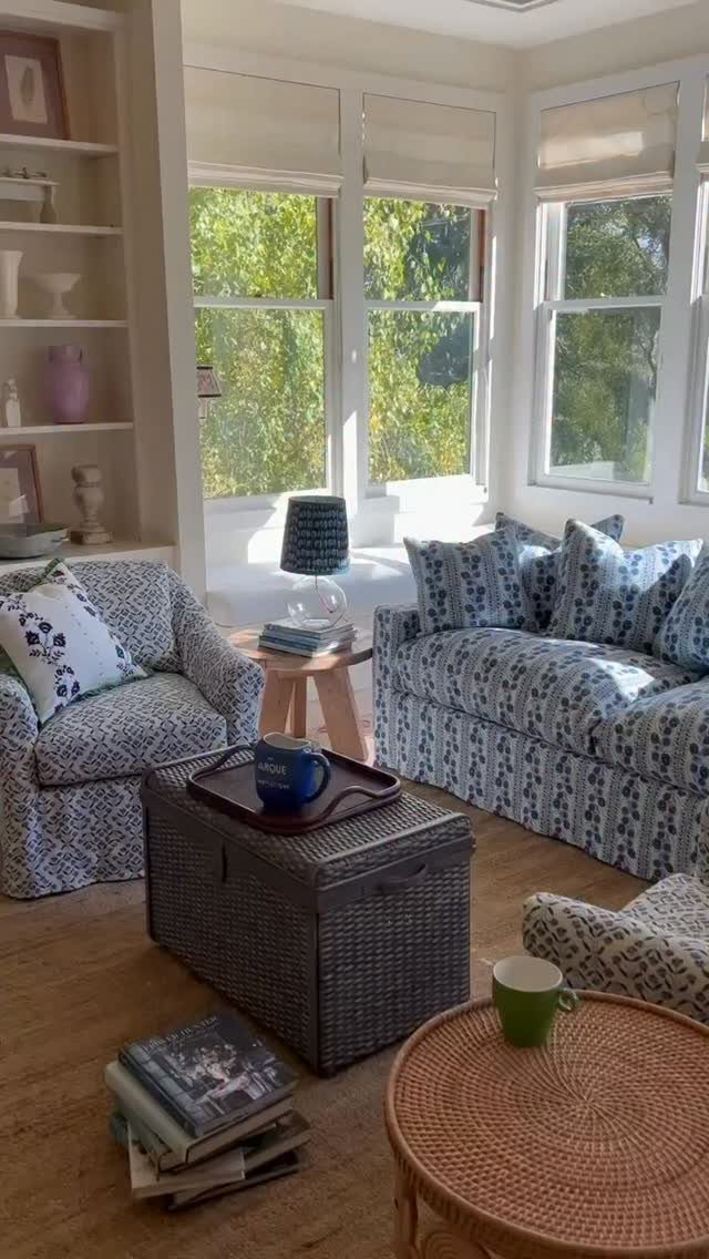 Blue and white patterned slipcovered sofa and armchair in a bright coastal living room.
