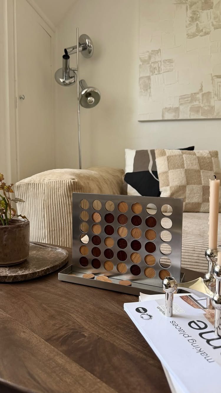Modern metal game board with wooden discs on a wooden coffee table.