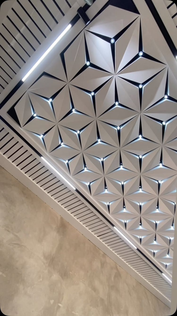 Geometric 3D ceiling panels with integrated LED lights and white slatted borders