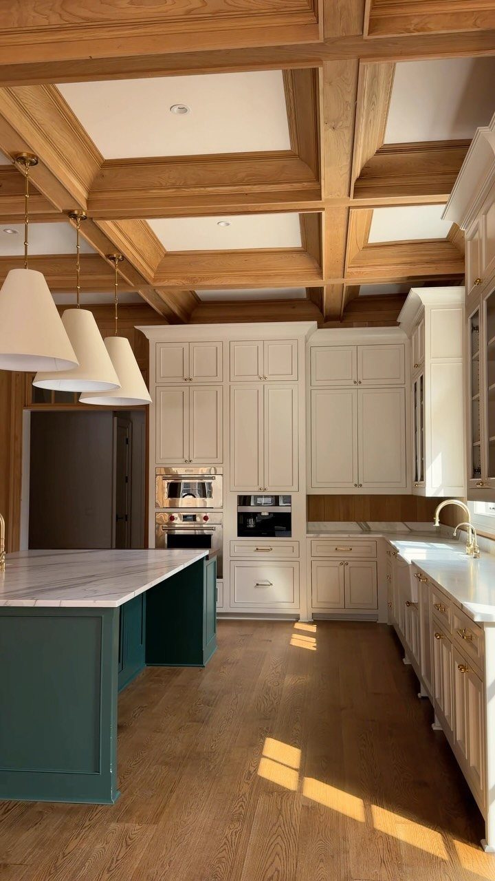 Kitchen with a light wood coffered ceiling, white cabinets, and a teal island.