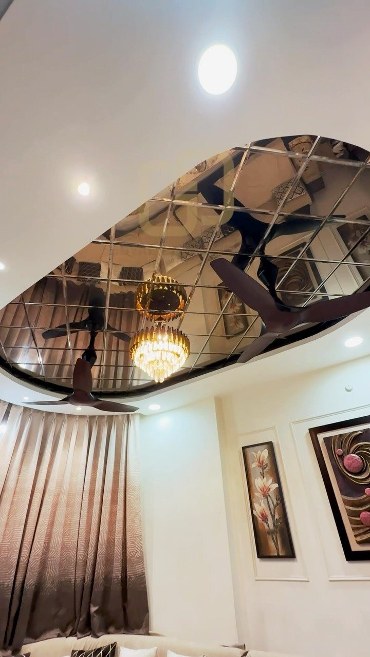 Mirrored coffered ceiling with a gold crystal chandelier and dark ceiling fan
