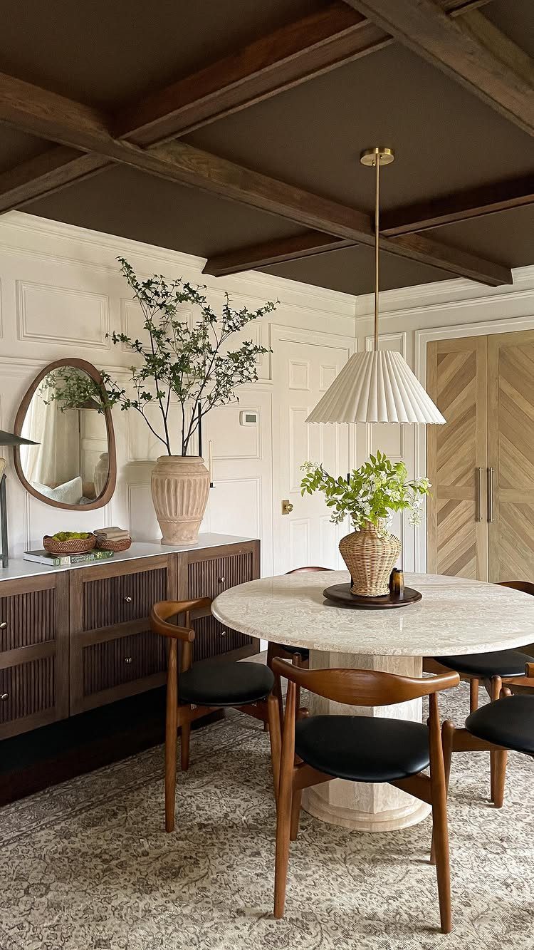Dark brown coffered ceiling with wooden beams above a modern white dining room.