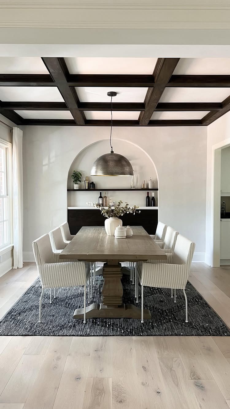 Dining room with a white coffered ceiling and dark brown wooden beams.