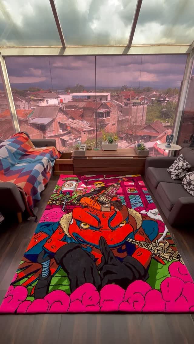 Colorful rug with red character in a living room overlooking a town.