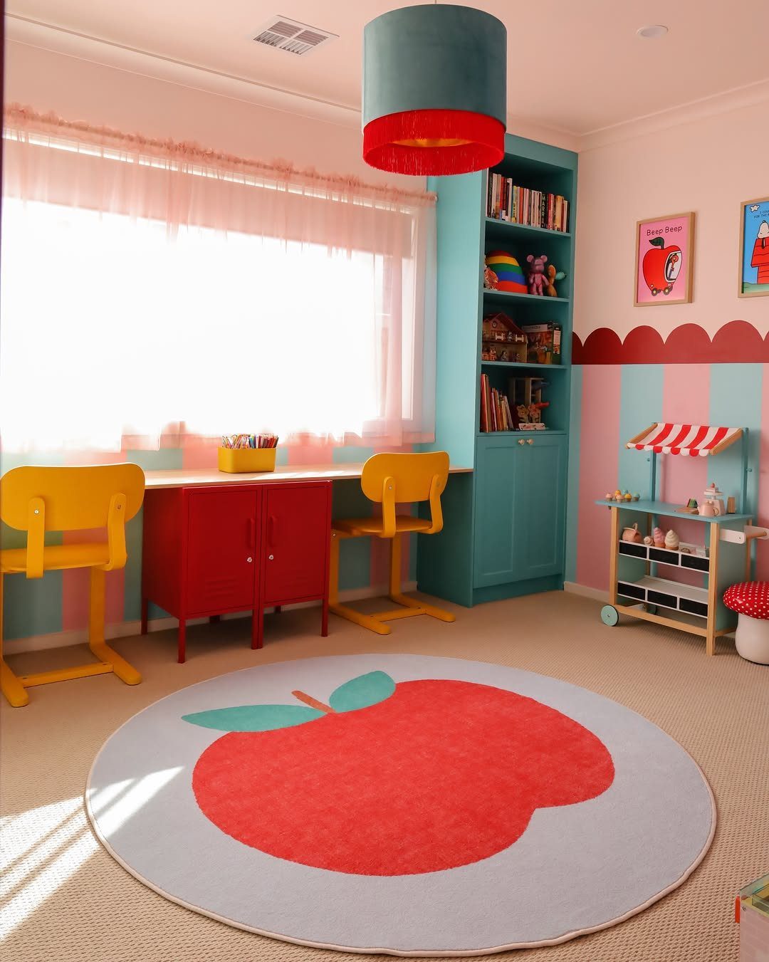 Colorful child's room with blue shelving, red furniture, and an apple-shaped rug.