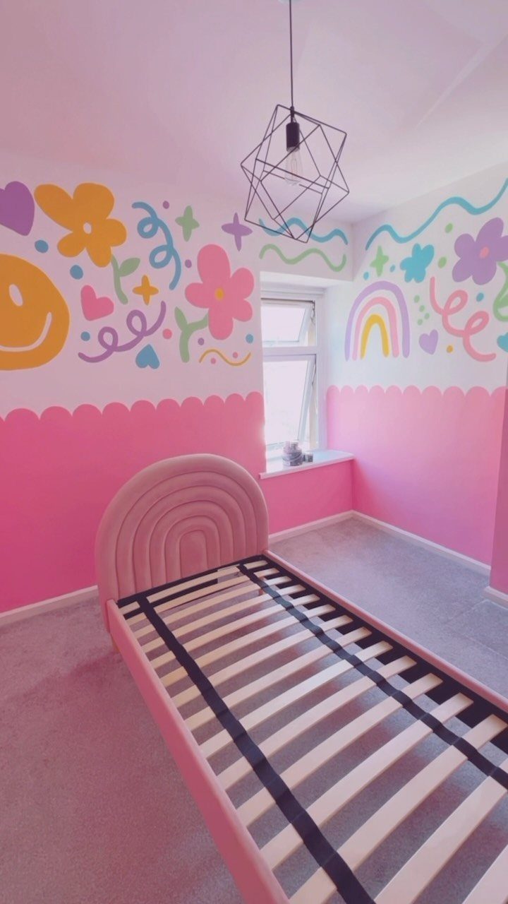 Pink bedroom with an arched headboard and colorful floral wall paintings.