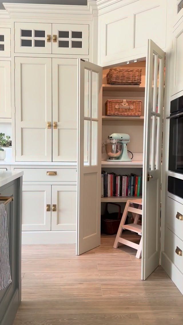 White built-in kitchen pantry corner with shelves, baskets, and a mint green mixer.