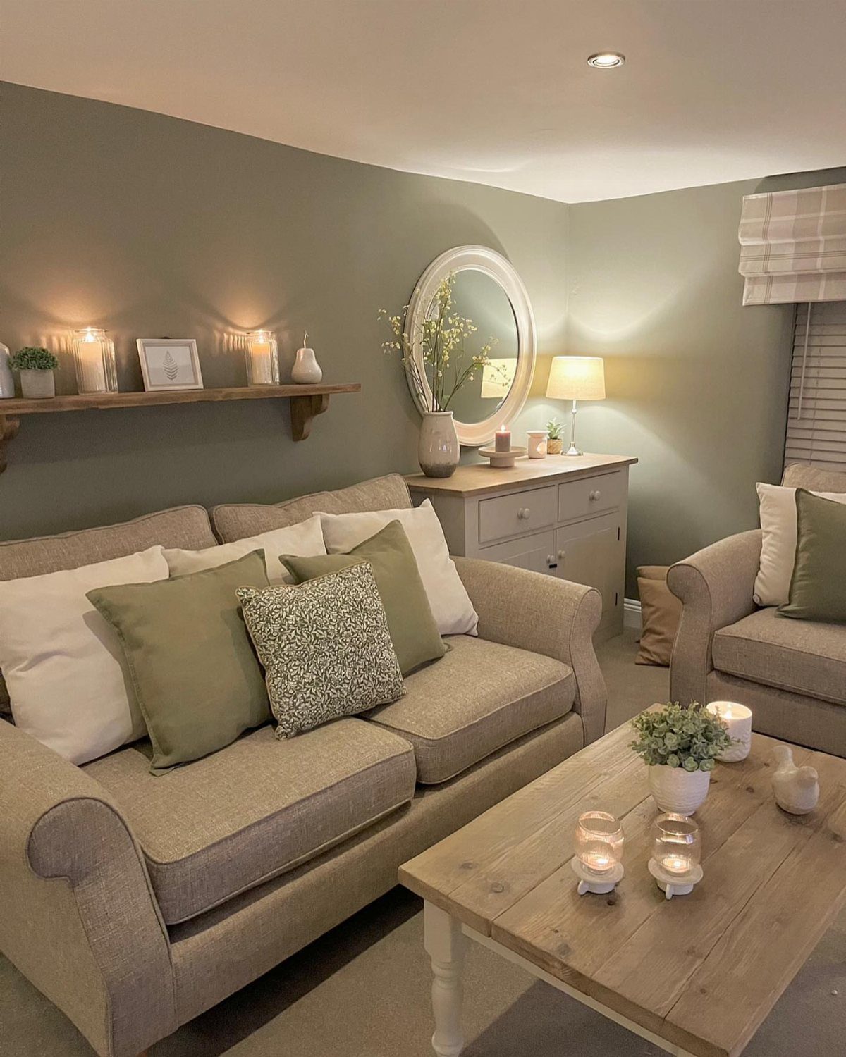 Beige sofa with green pillows and wooden coffee table in a cottage living room.