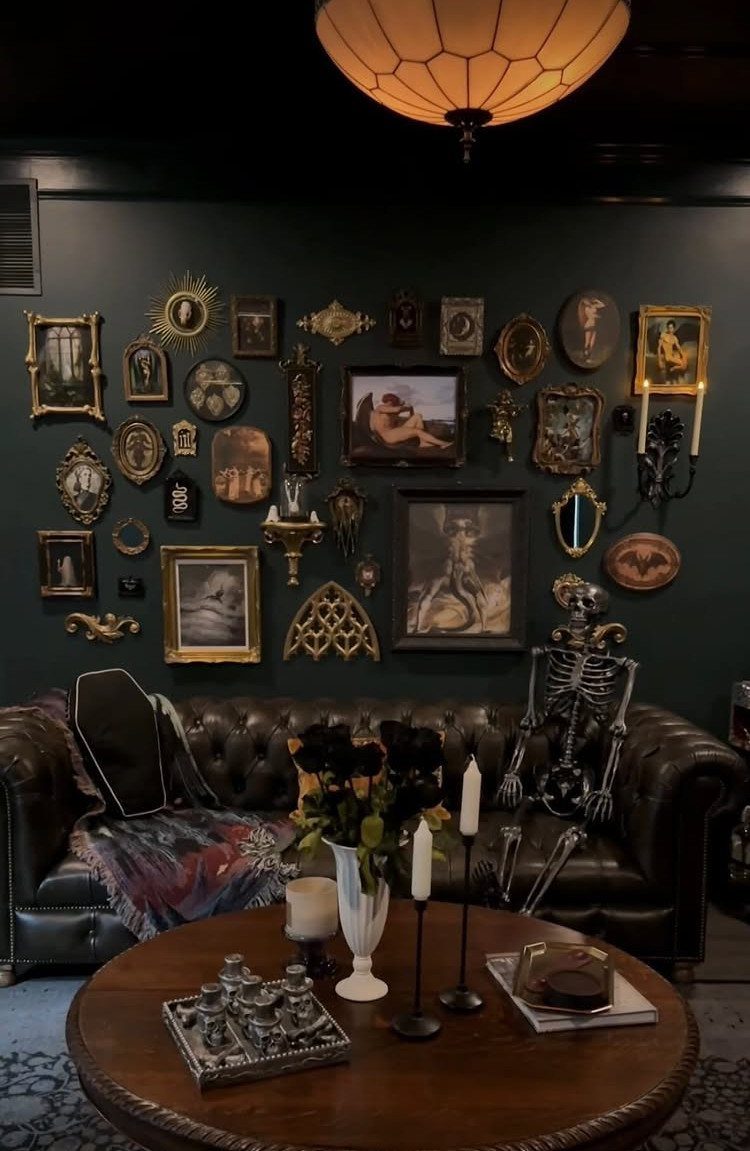 Dark brown leather sofa with a dense gallery wall of gold-framed art behind it.