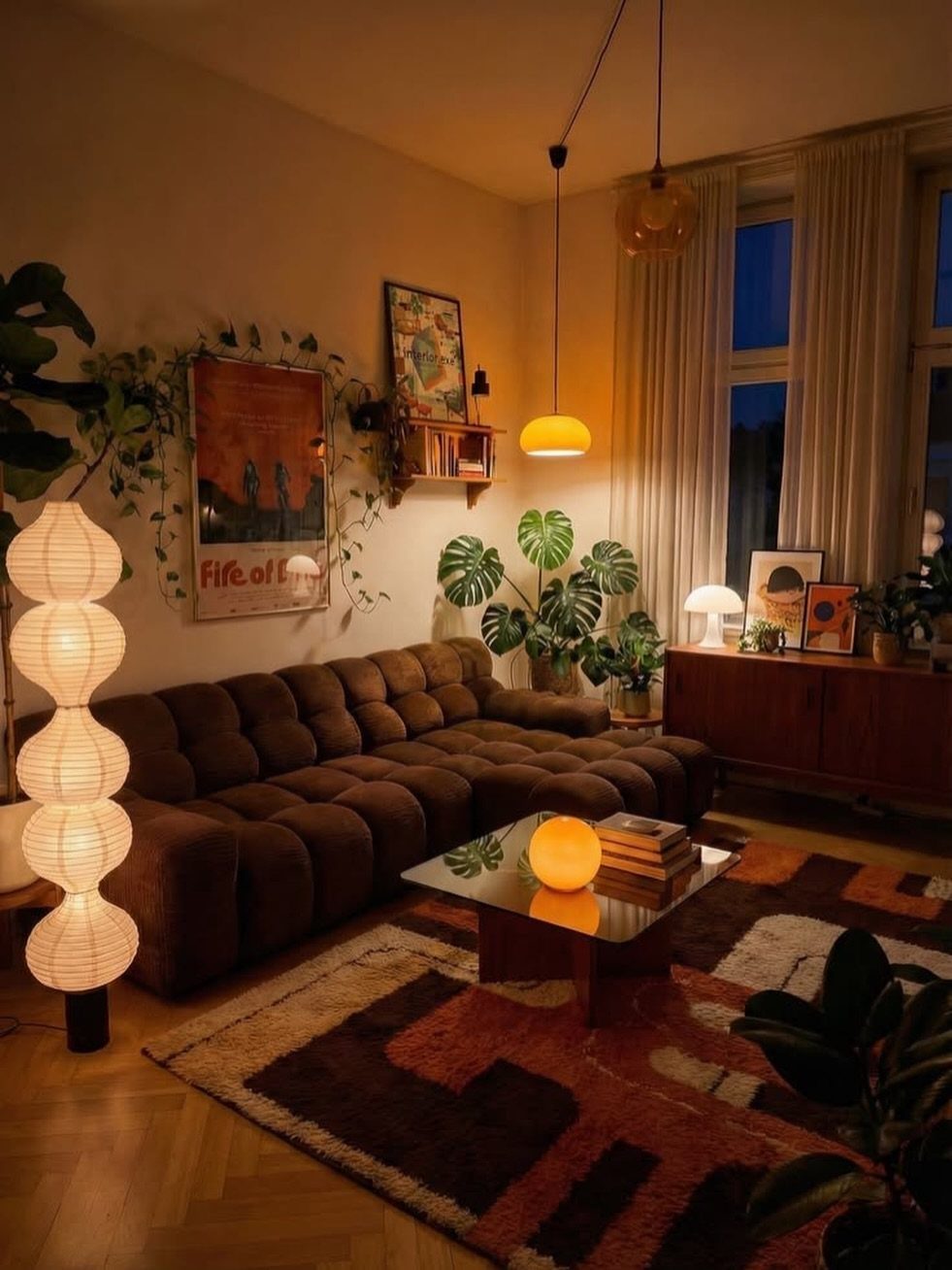 Dark brown modular sofa surrounded by lush green indoor plants and warm ambient lighting.
