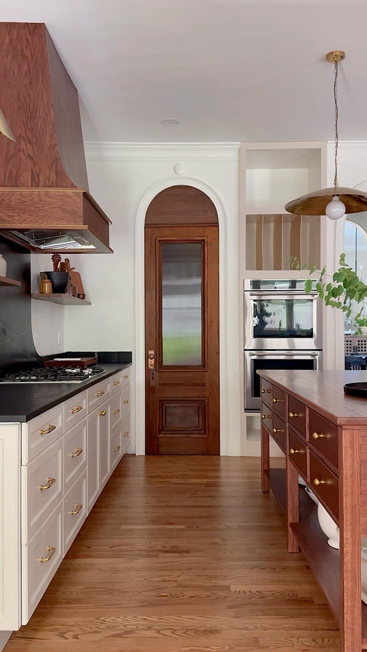 Wooden door with thick white arched trim in a modern kitchen setting