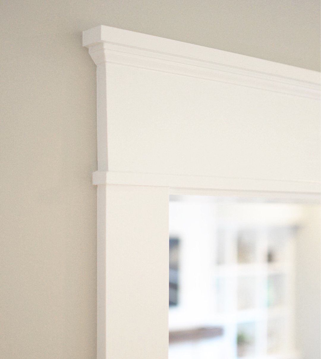 White Craftsman style door trim with a thick header and crown molding.