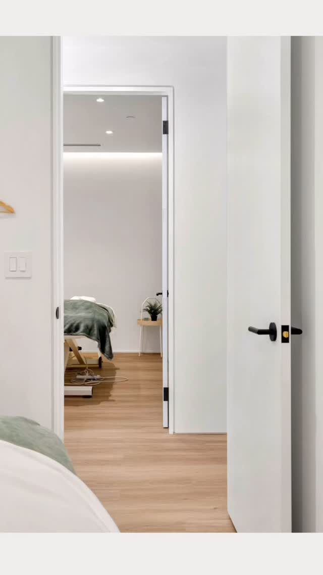 White door with minimal trim and light wood floors in a bright interior.