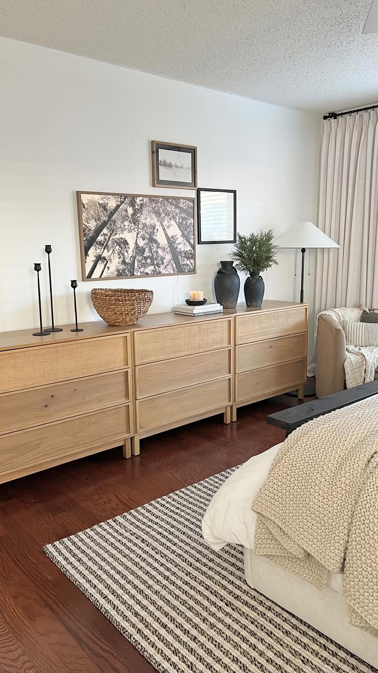 Light wood dresser with framed art layered on the wall above it.