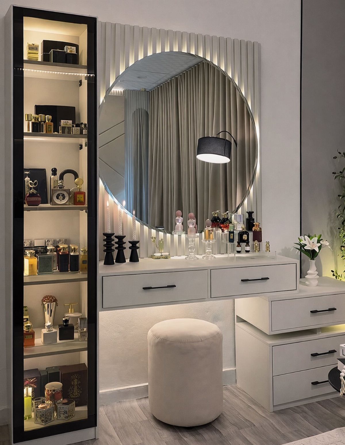 White dresser vanity with a large circular mirror and perfume bottle displays.