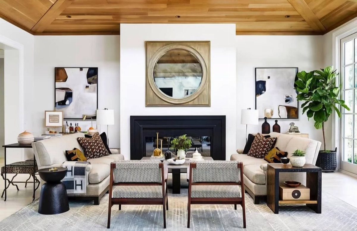 Symmetrical family room with matching sofas, armchairs, and art flanking a central fireplace.