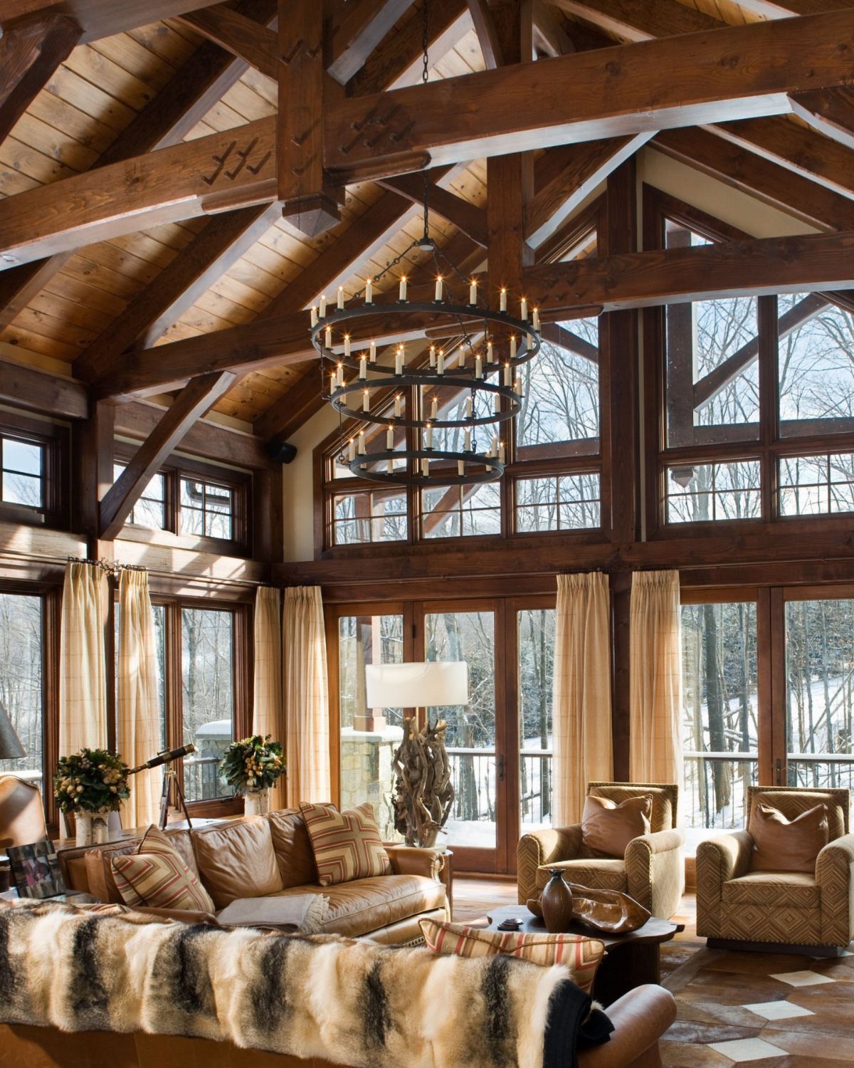 Vaulted ceiling with heavy dark wood beams and a large tiered circular chandelier.