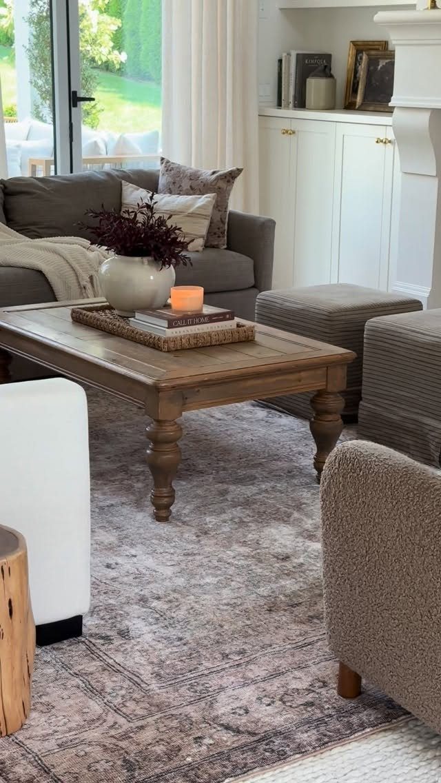 Grey patterned area rug layered over a white rug in a farmhouse living room.
