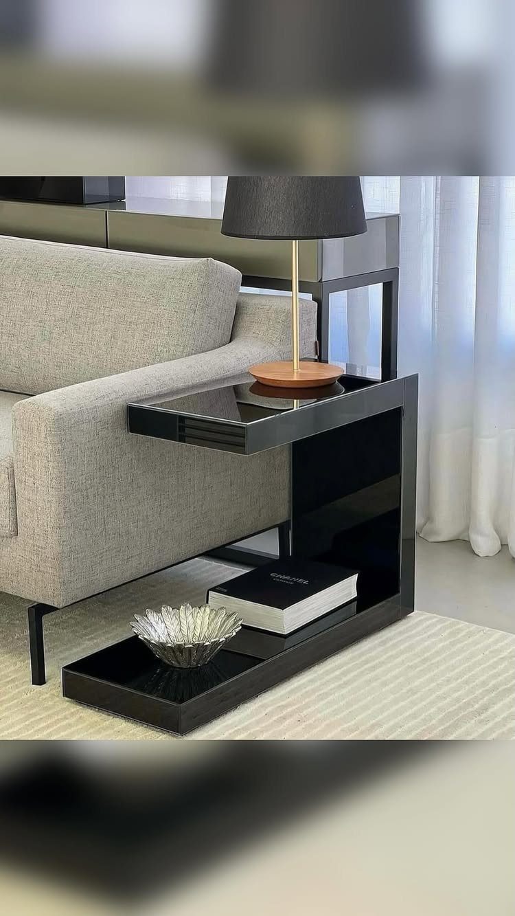 Grey fabric sofa and black side table on a cream ribbed area rug