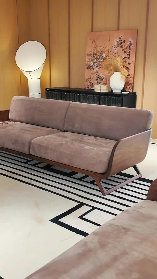 Low-profile taupe sofa with wooden frame on a geometric black and white rug