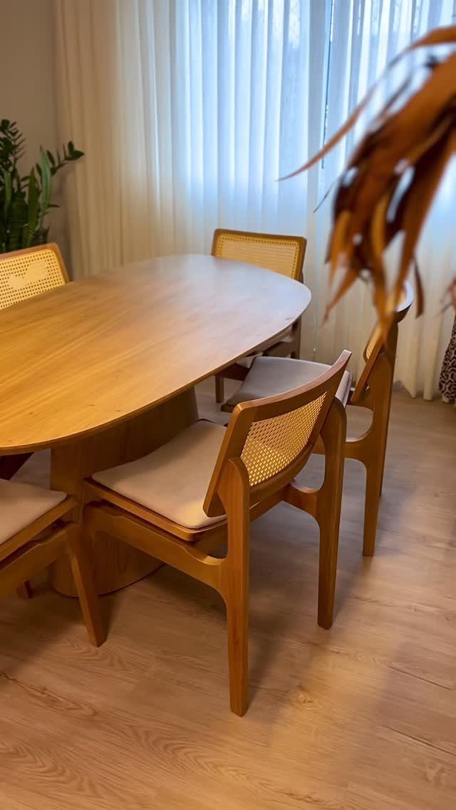 Oval wooden dining table and cane-back chairs on a light wood floor.