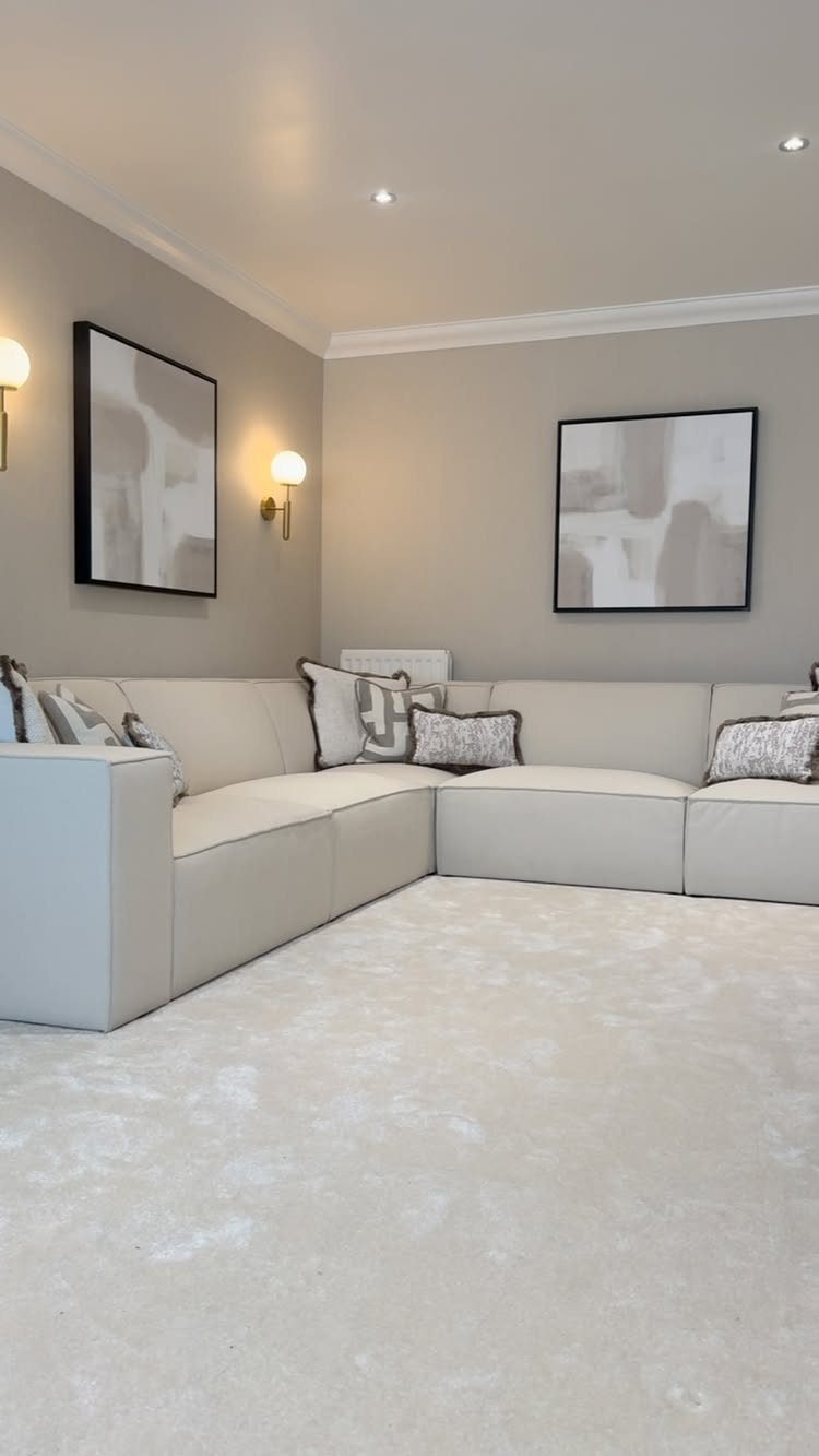 Light gray living room with a white sectional sofa and abstract wall art
