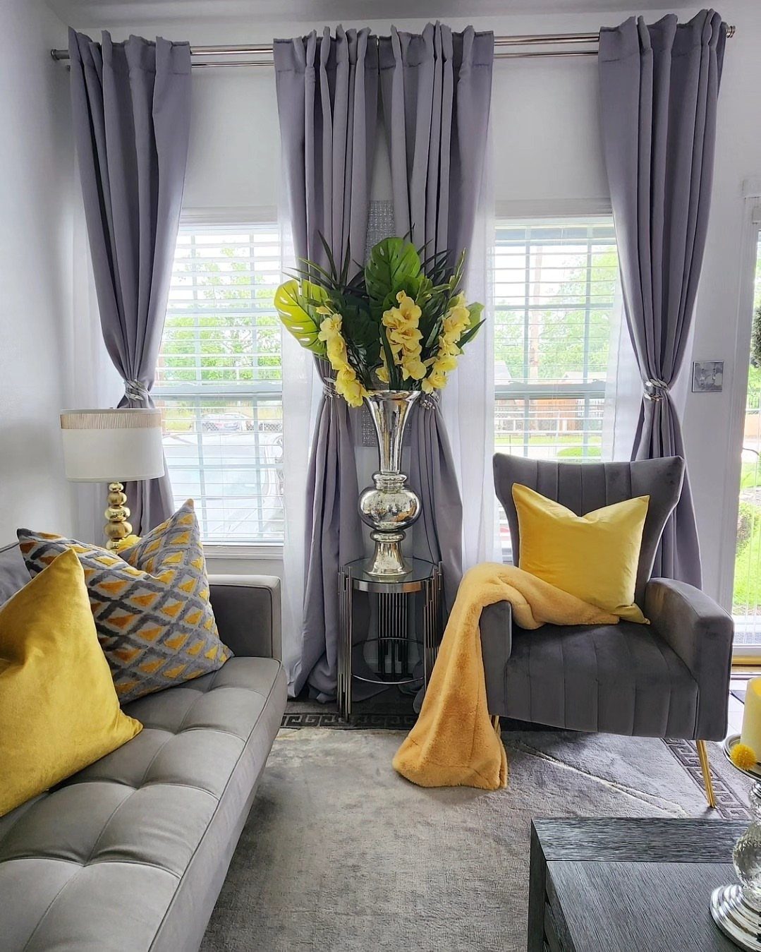 Gray living room with a sofa and armchair featuring bright yellow accent cushions.