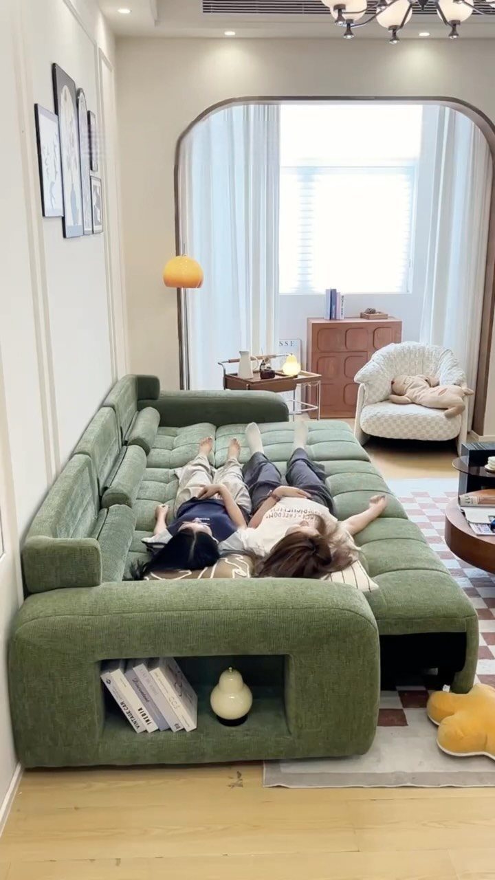 Large bold green sectional sofa with people lounging in a bright modern living room