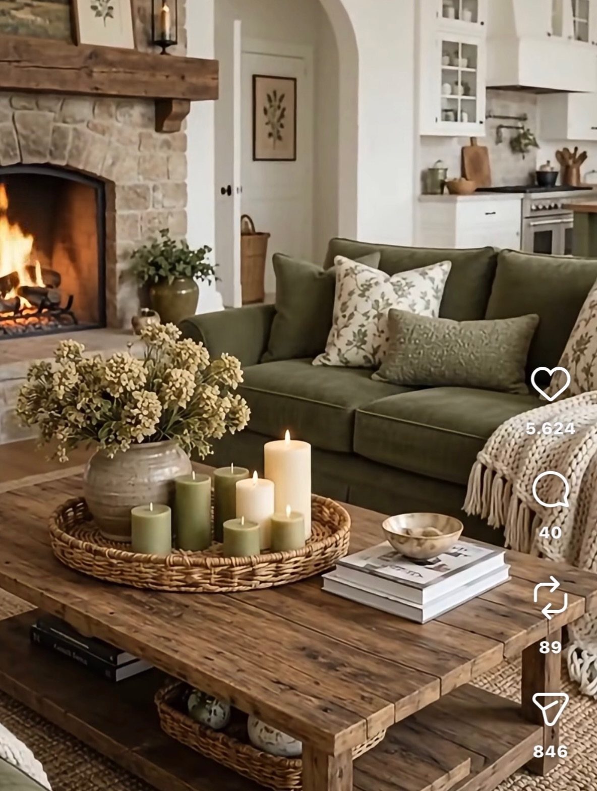 Green fabric sofa facing a stone fireplace with a rustic wooden coffee table.