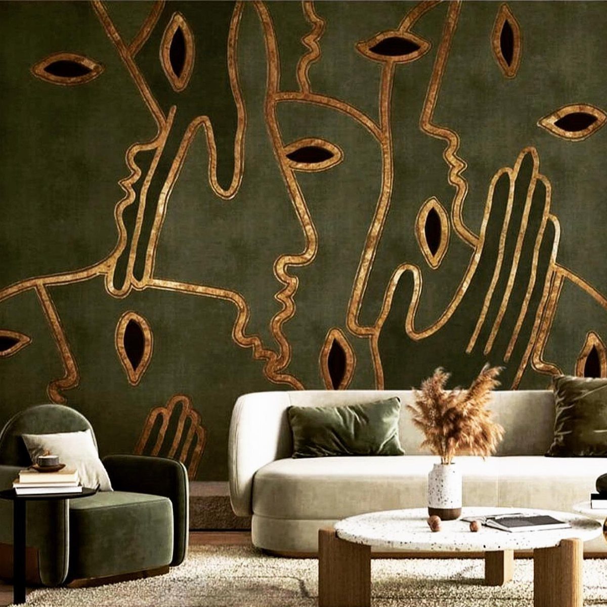 Dark green wallpaper with gold abstract faces behind a white curved sofa.