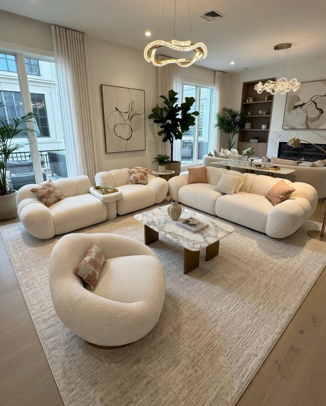 Curved white bouclé sofas and marble coffee table in a modern luxury living room