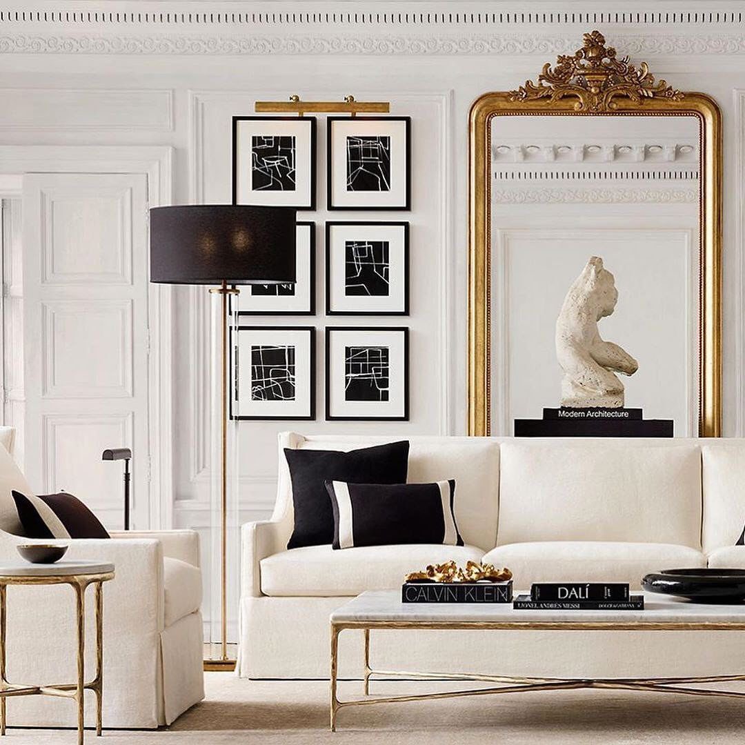 White luxury sofa and armchair with gold accents in a bright, classical room.
