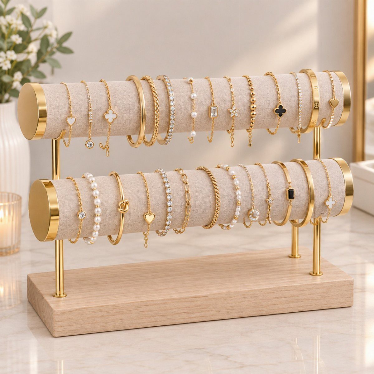 Two-tiered gold and wood jewelry stand displaying various gold bracelets and necklaces.