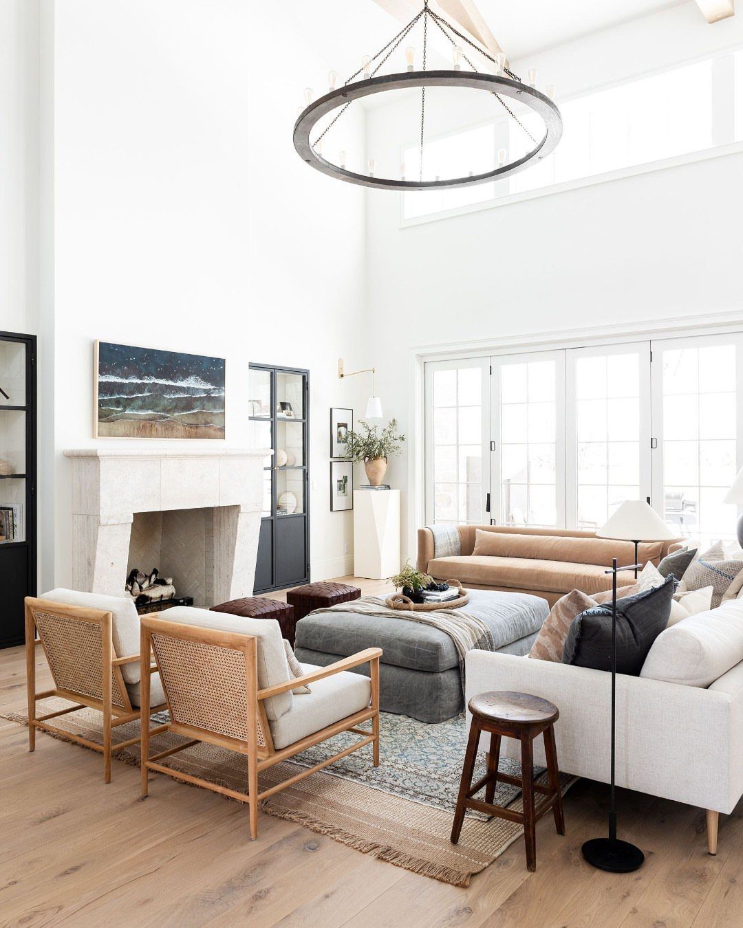 Layered rugs in a bright living room with white and tan furniture.