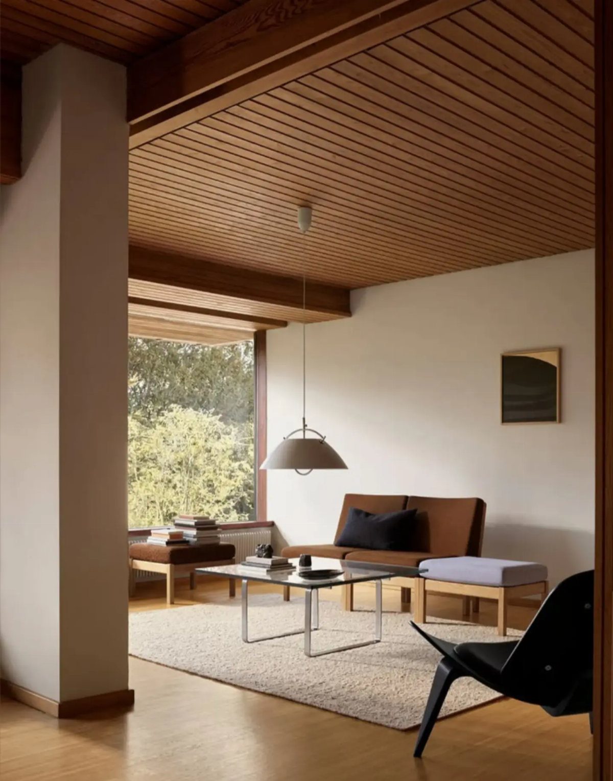Wooden slat ceiling in a modern living room with minimalist furniture and neutral tones.